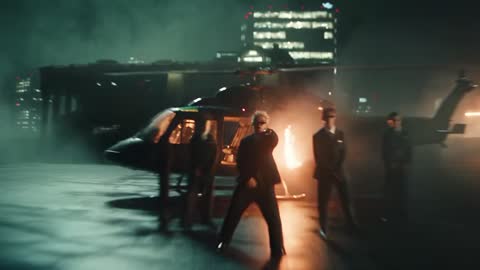 A man in sunglasses lit by warm light in a cinematic night scene
